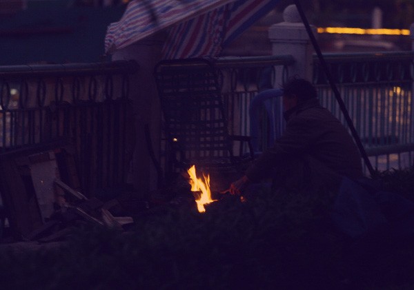 Một người dân nhóm lửa sưởi ấm ven Hồ Tây